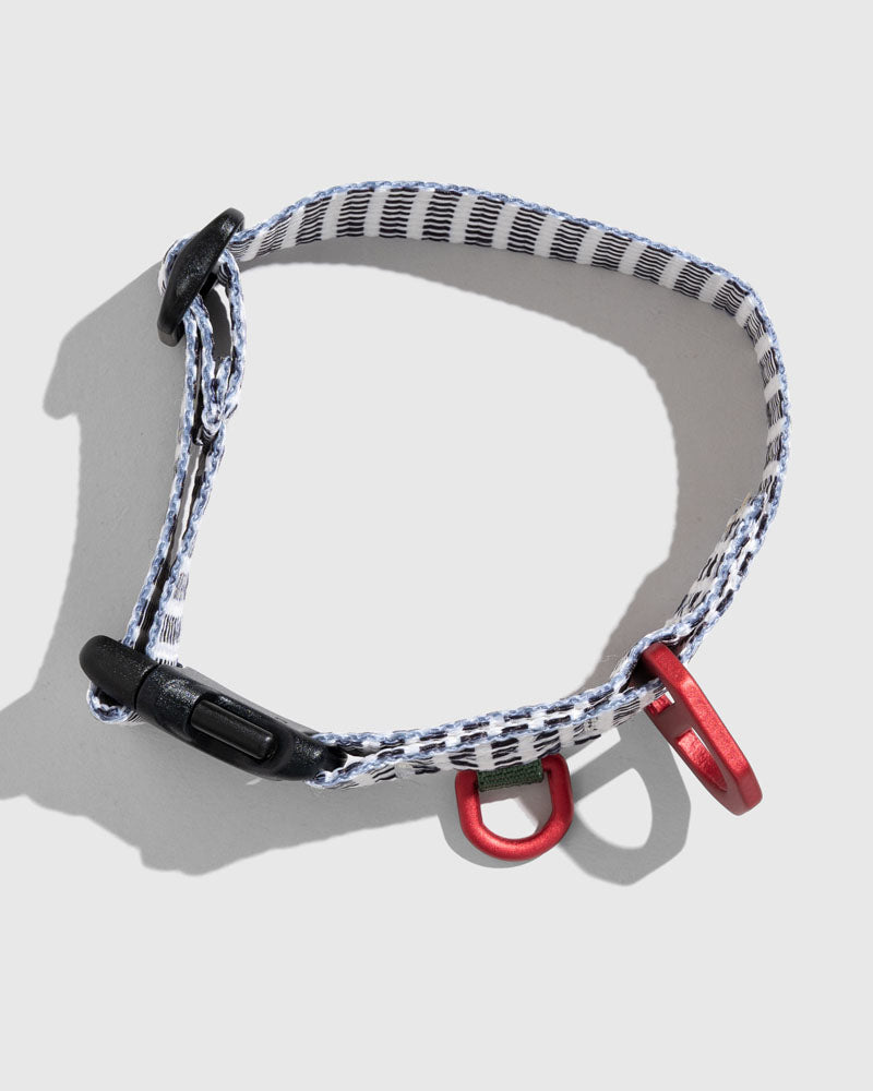 Shortbread (R)evolution™ Recycled Woven Dog Collar (Flat-lay): White woven collar with black pattern, black buckle, red metal rings