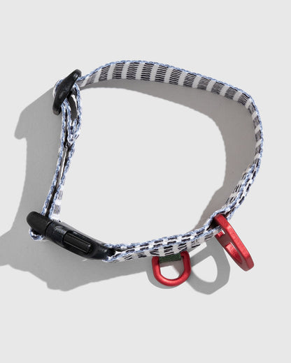 Shortbread (R)evolution™ Recycled Woven Dog Collar (Flat-lay): White woven collar with black pattern, black buckle, red metal rings