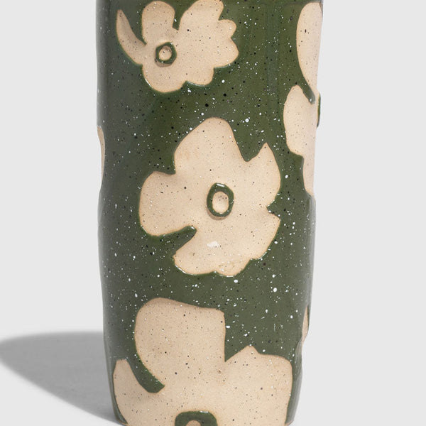Forest Floor 10 oz. Insulated Stoneware Travel Mug (Angle): Cylindrical ceramic mug, olive green glaze with raised cream floral motifs, black lid