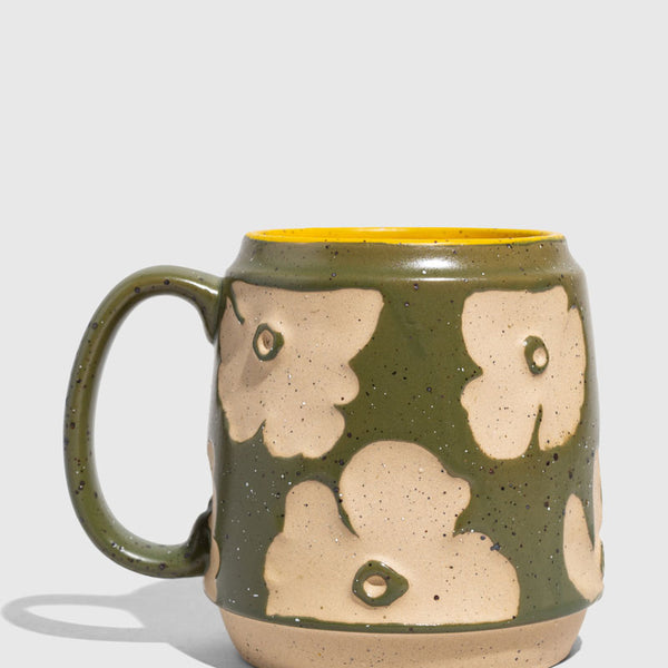 Forest Floor 16 oz. Stoneware Mug (Angle): Green speckled stoneware mug with raised cream floral pattern and yellow interior