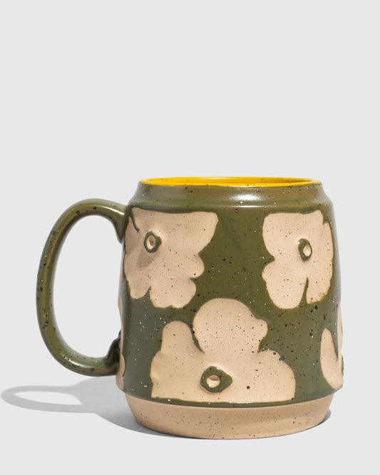 Forest Floor 16 oz. Stoneware Mug (Angle): Green speckled stoneware mug with raised cream floral pattern and yellow interior