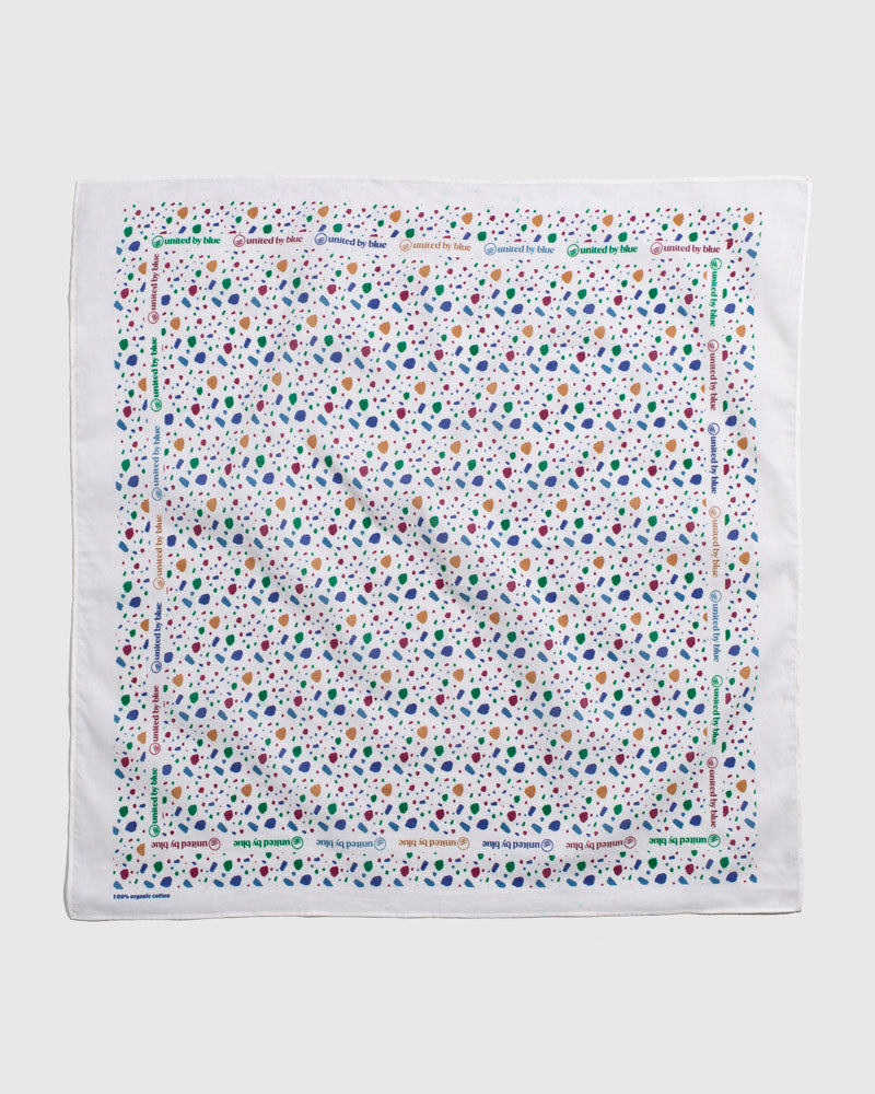 Egret Organic Bandana (Flat-lay): White bandana with multicolor abstract spots and repeated brand text border