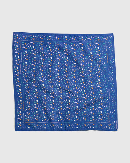 Lagoon Organic Bandana (Flat-lay): Royal blue bandana with scattered multicolor shapes and brand text border