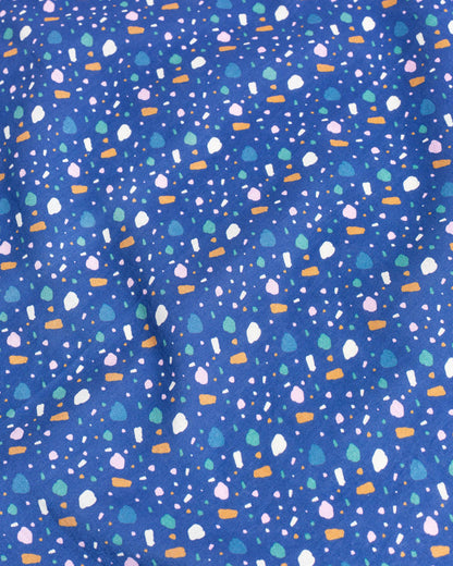Lagoon Organic Bandana (Detail): Blue fabric with scattered multicolor confetti shapes in white, pink, green, and orange