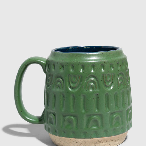 Pine 16 oz. Stoneware Mug (Angle): Forest green speckled ceramic mug with embossed arch pattern and navy interior
