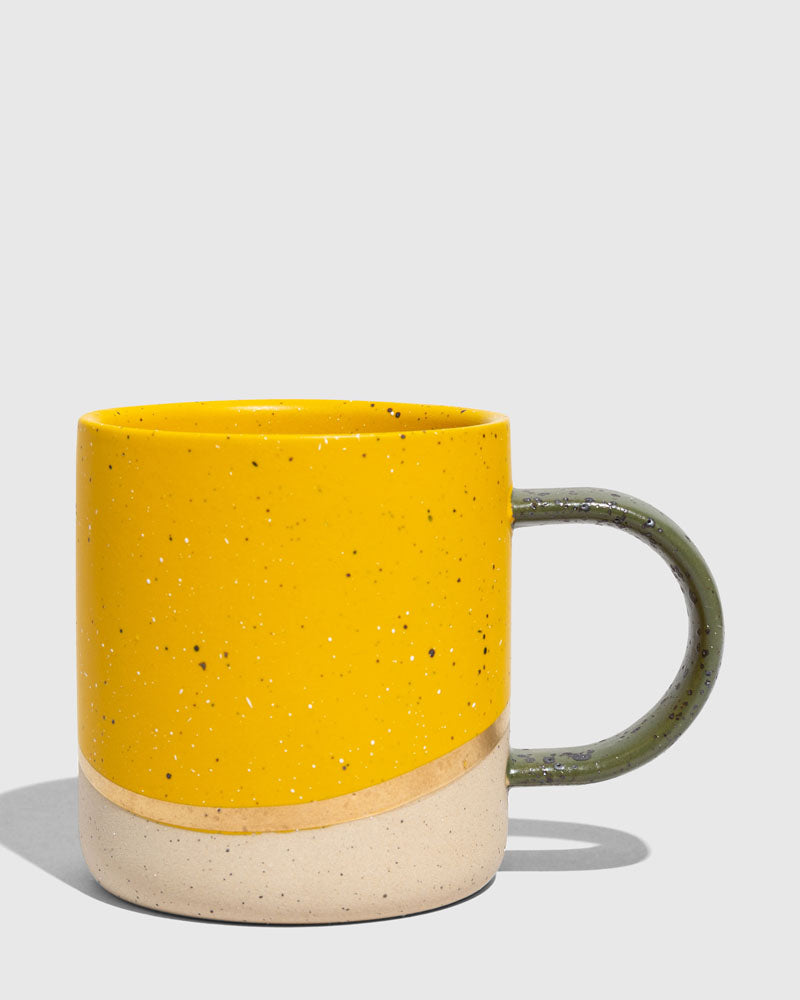 Butterscotch 8 oz. Stoneware Mug (Angle): Yellow speckled ceramic mug with unglazed base and olive green handle