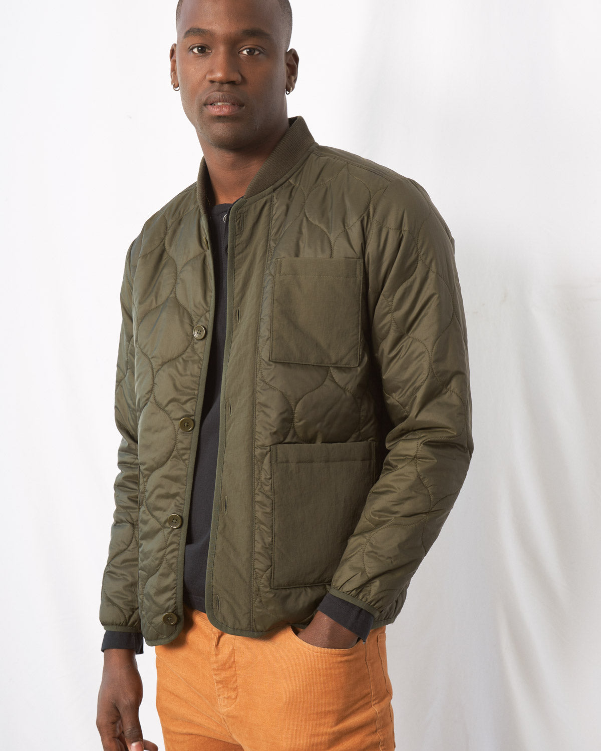 Forest Floor Bison Ultralight Liner Jacket (Angle): Olive quilted bomber jacket with button front, chest and waist pockets