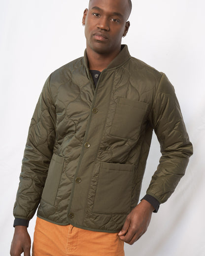 Forest Floor Bison Ultralight Liner Jacket (Angle): Olive quilted button-front jacket with chest and lower patch pockets, worn by a man