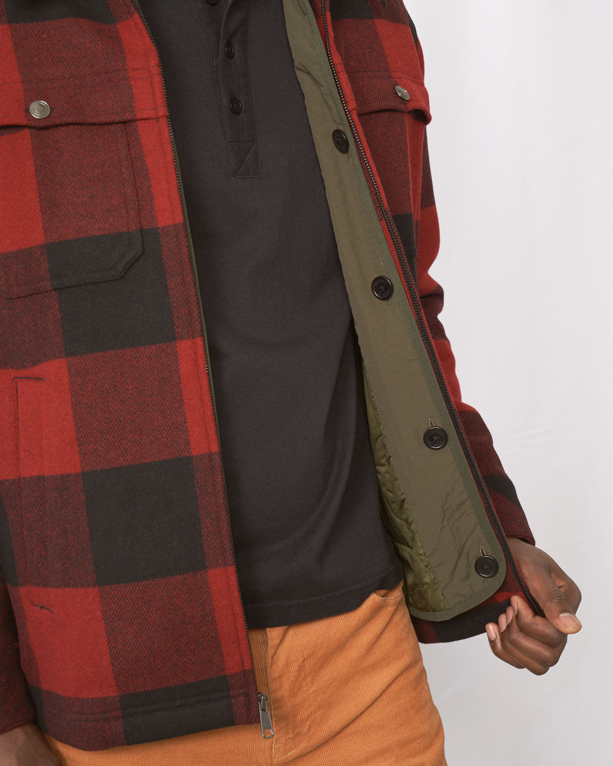 Forest Floor Bison Ultralight Liner Jacket (Detail): Olive quilted liner jacket interior shown open against red plaid overshirt
