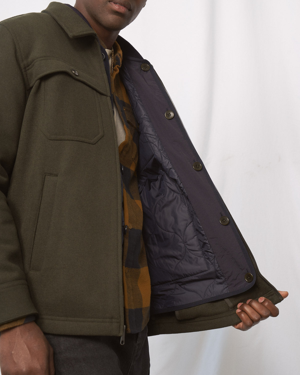 Night Sky Bison Ultralight Liner Jacket (Detail): Dark navy quilted interior lining with buttons shown open on olive jacket