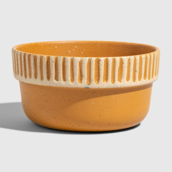 Caramel Stoneware Stackable Bowl (Angle): Round ceramic bowl, warm amber glaze, ribbed cream band near rim