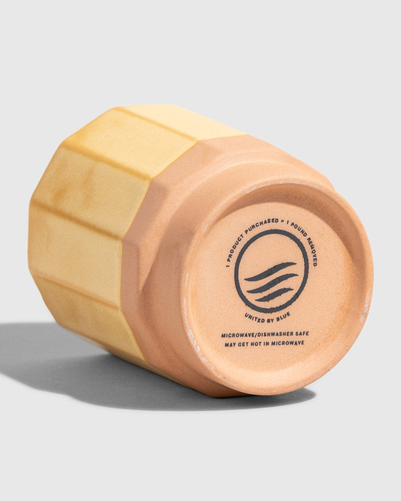 Honey 8 oz. Stackable Stoneware Tumbler (Detail): Bottom of yellow faceted tumbler showing brand logo and care instructions