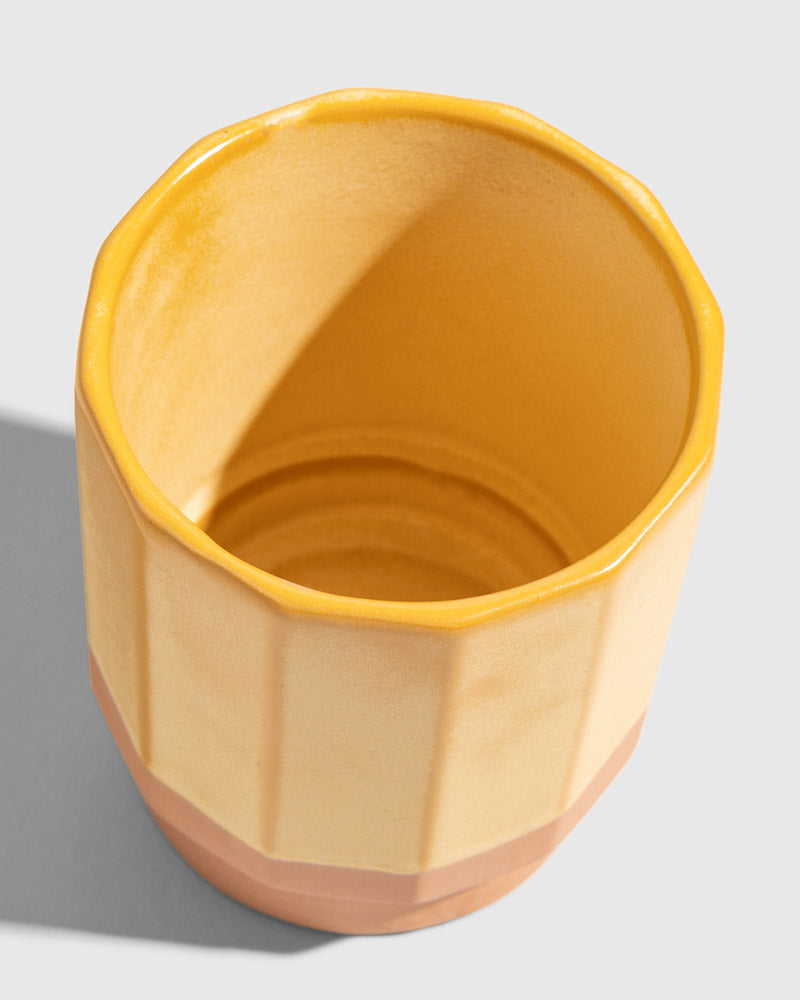 Honey 8 oz. Stackable Stoneware Tumbler (Detail): Yellow-glazed stoneware tumbler viewed from above, showing interior and faceted sides
