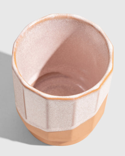 Foxglove 8 oz. Stackable Stoneware Tumbler (Detail): Top-down view inside pale pink glazed tumbler with ribbed exterior and unglazed base