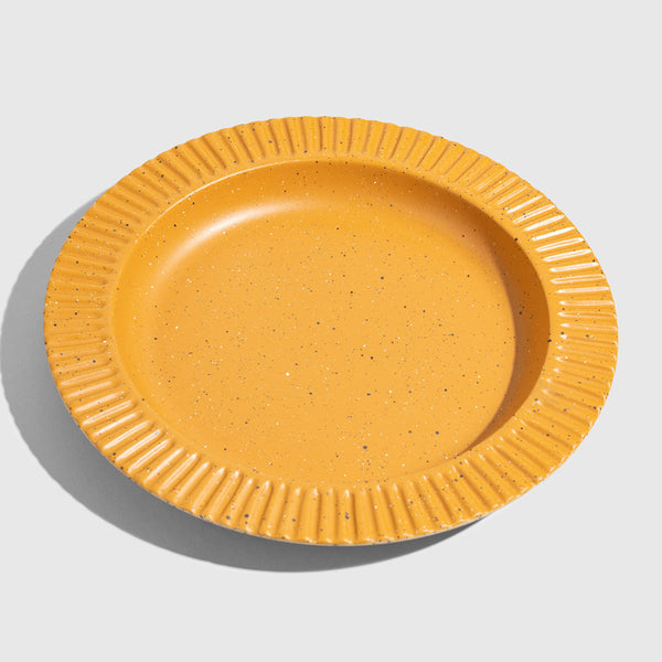 Caramel Stoneware Stackable Plate (Angle): Round mustard yellow speckled plate with ridged scalloped rim border