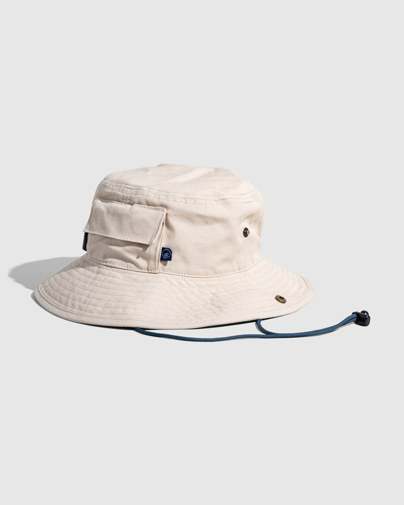 Bone Organic Bucket Stash Hat (Angle): Off-white boonie hat with side pocket, brass eyelets, and navy chin cord