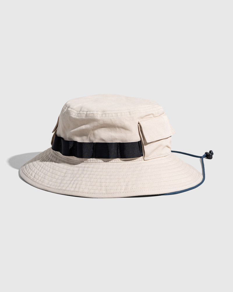 Bone Organic Bucket Stash Hat (Angle): Off-white boonie hat with black grosgrain band, side pockets, and chin cord