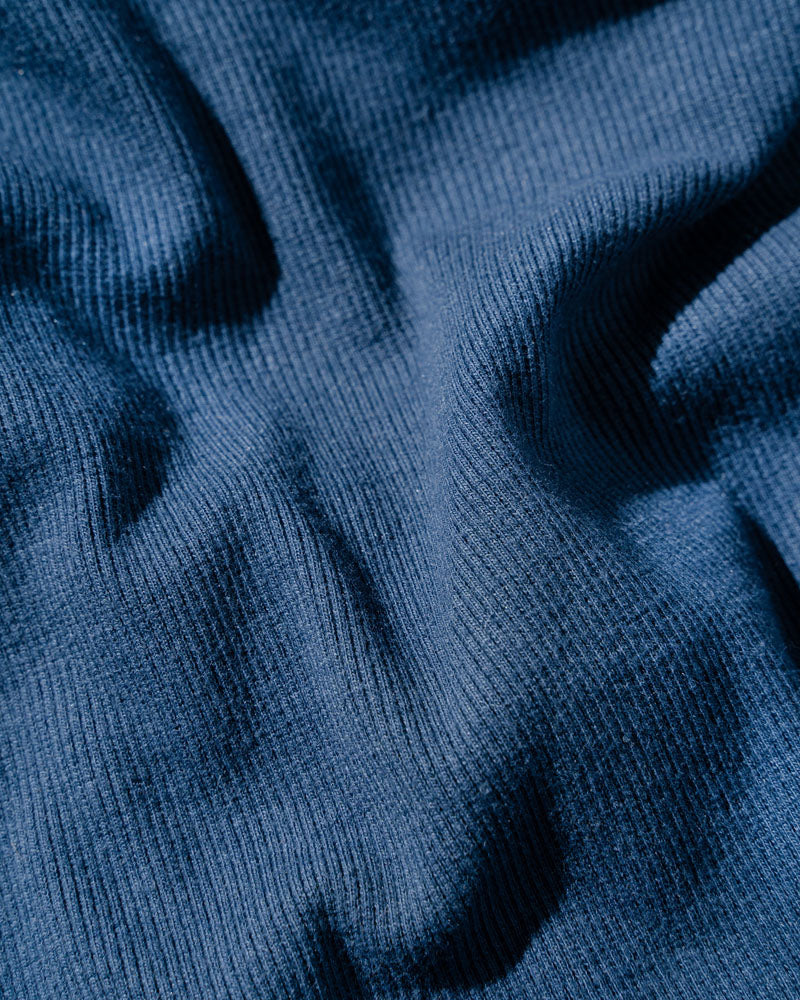 Midnight EcoKnit™ Ribbed Bike Short (Detail): Close-up of ribbed navy blue fabric with soft folds and texture