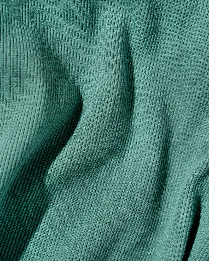 Jade EcoKnit™ Ribbed Bike Short (Detail): Close-up of teal ribbed knit fabric with soft draping folds