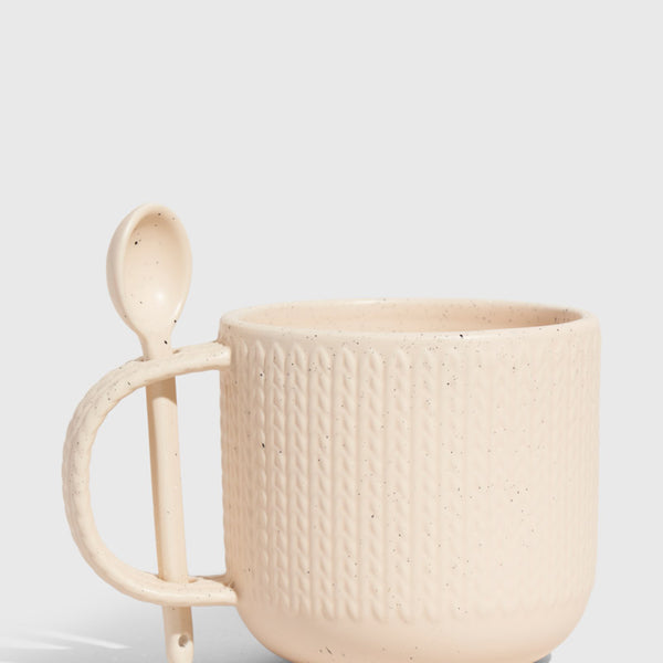 Shortbread 14 oz. Stoneware Spoon Mug (Angle): Cream speckled stoneware mug with knit texture and attached ceramic spoon