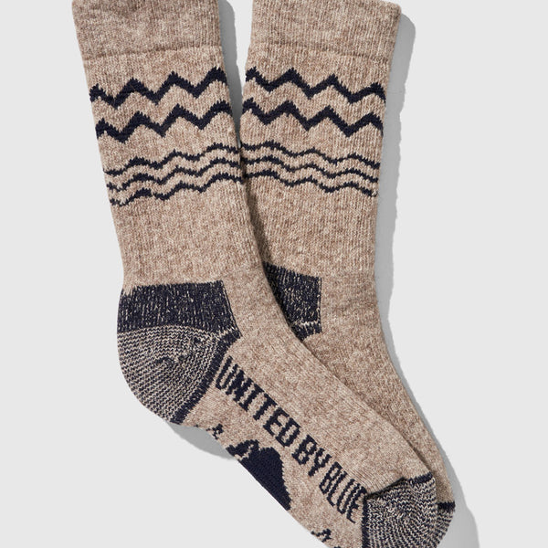 Navy The Ultimate Bison Wool Sock (Flat-lay): Tan crew socks with navy zigzag, wave stripes, and reinforced heel toe