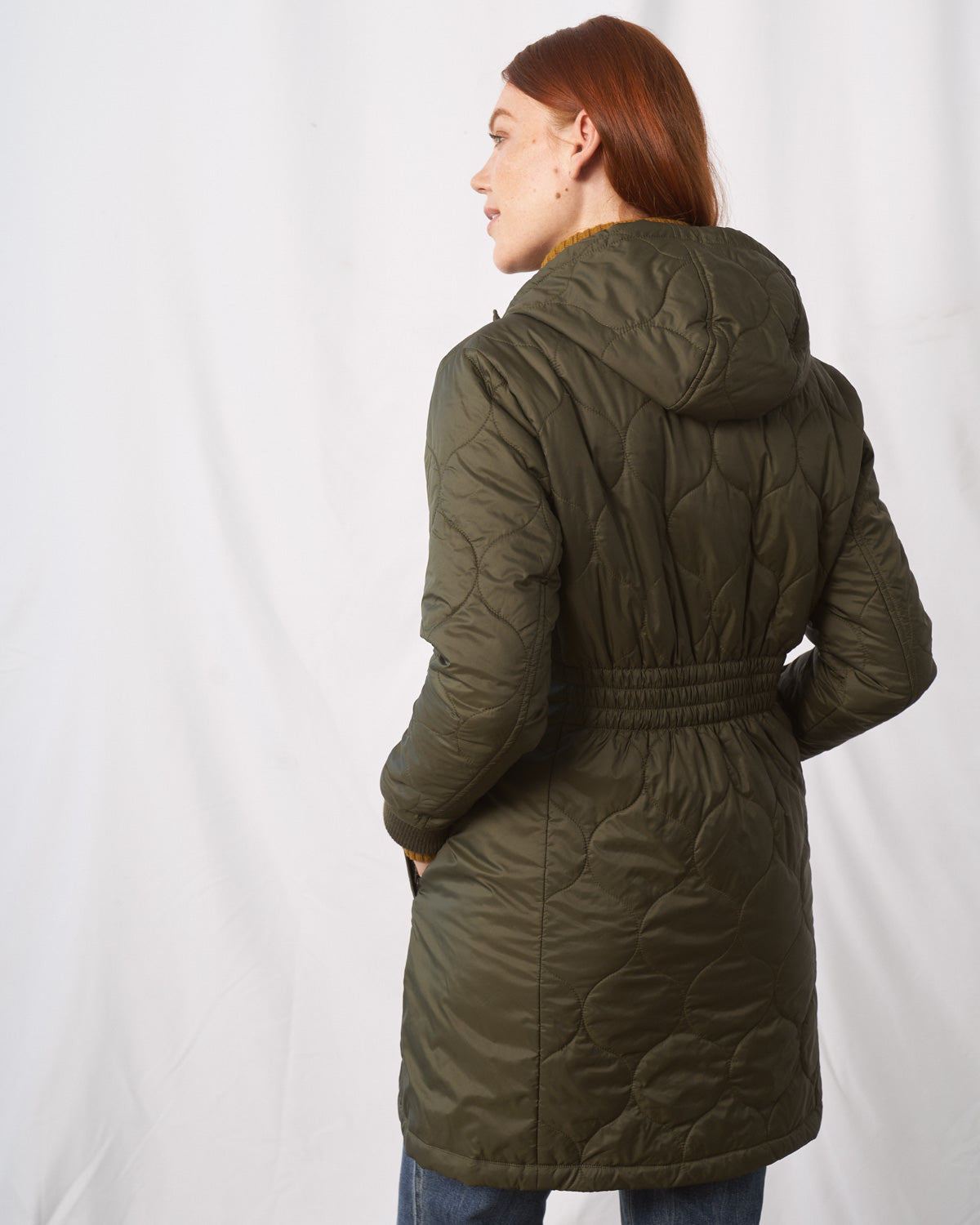 Forest Floor Bison Ultralight Long Liner Jacket (Back): Olive green quilted hooded coat with scallop stitching and elasticated waist