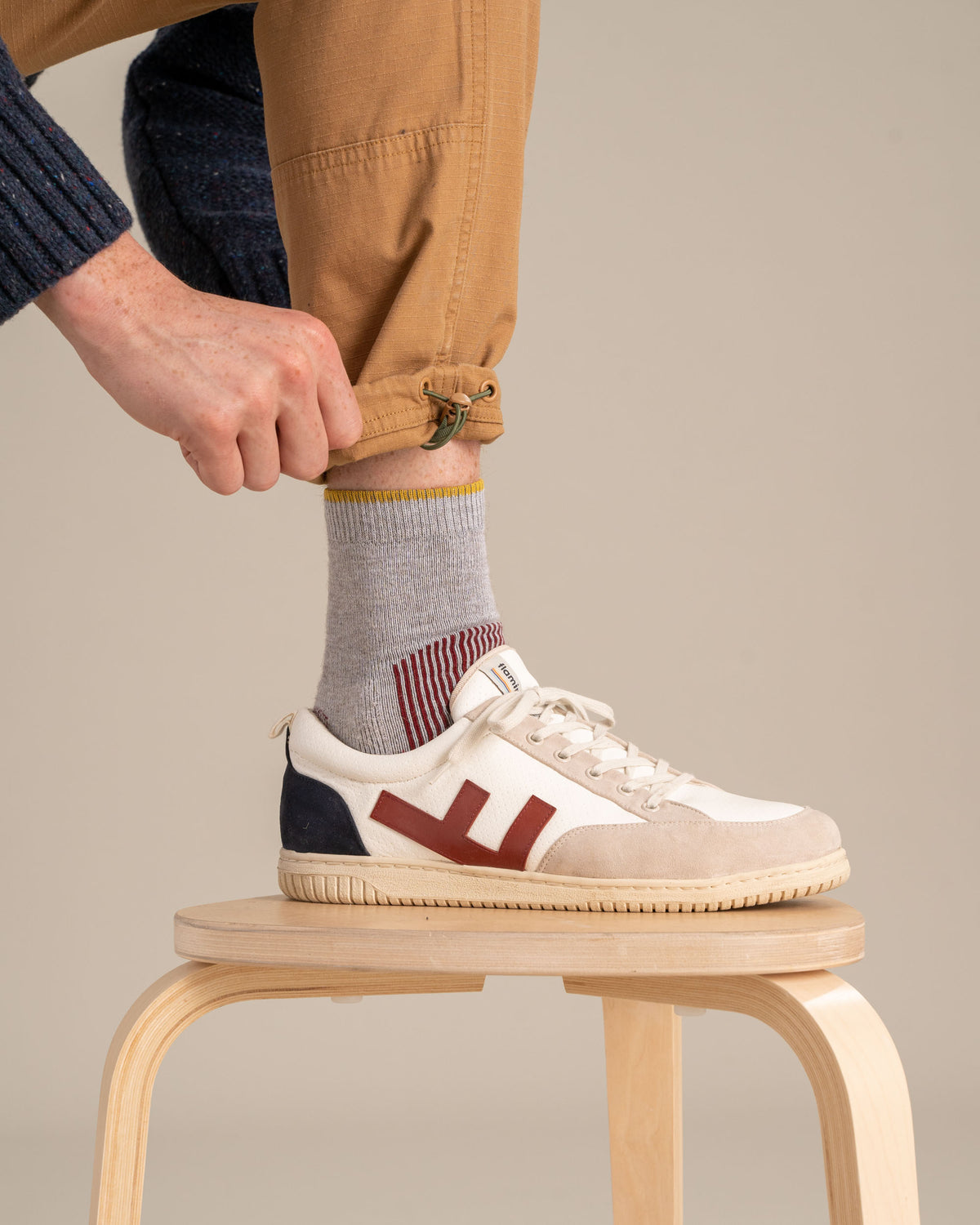 Red Bison Wool Trail Sock (In-use): Gray sock with yellow trim and red stripes, worn with white sneakers