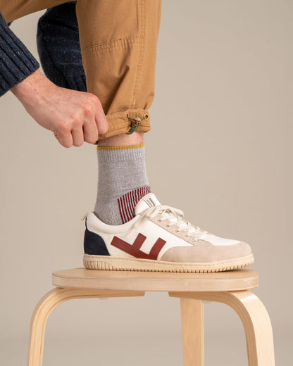 Red Bison Wool Trail Sock (In-use): Gray crew sock with yellow cuff stripe worn with white sneaker
