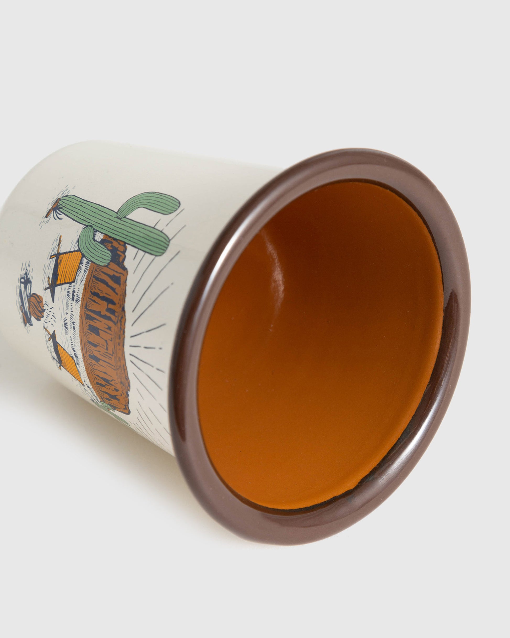 Cream Desert Chill Enamel 12 Oz. Tumbler (Detail): Ceramic tumbler tipped on side showing orange glazed interior and brown rim