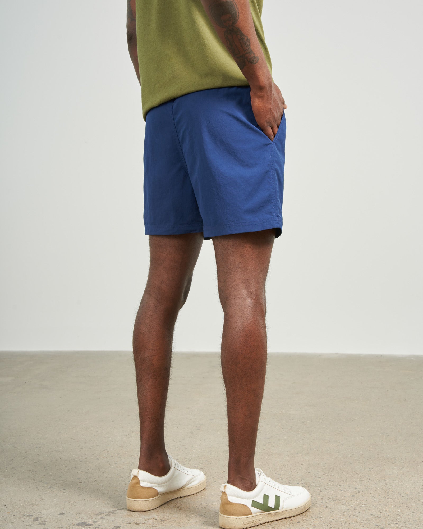 Estate Blue Recycled Sport Short (Back): Navy blue shorts on male model, rear view, white sneakers