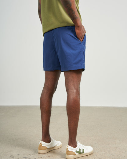 Estate Blue Recycled Sport Short (Back): Navy blue shorts on male model, rear view, white sneakers