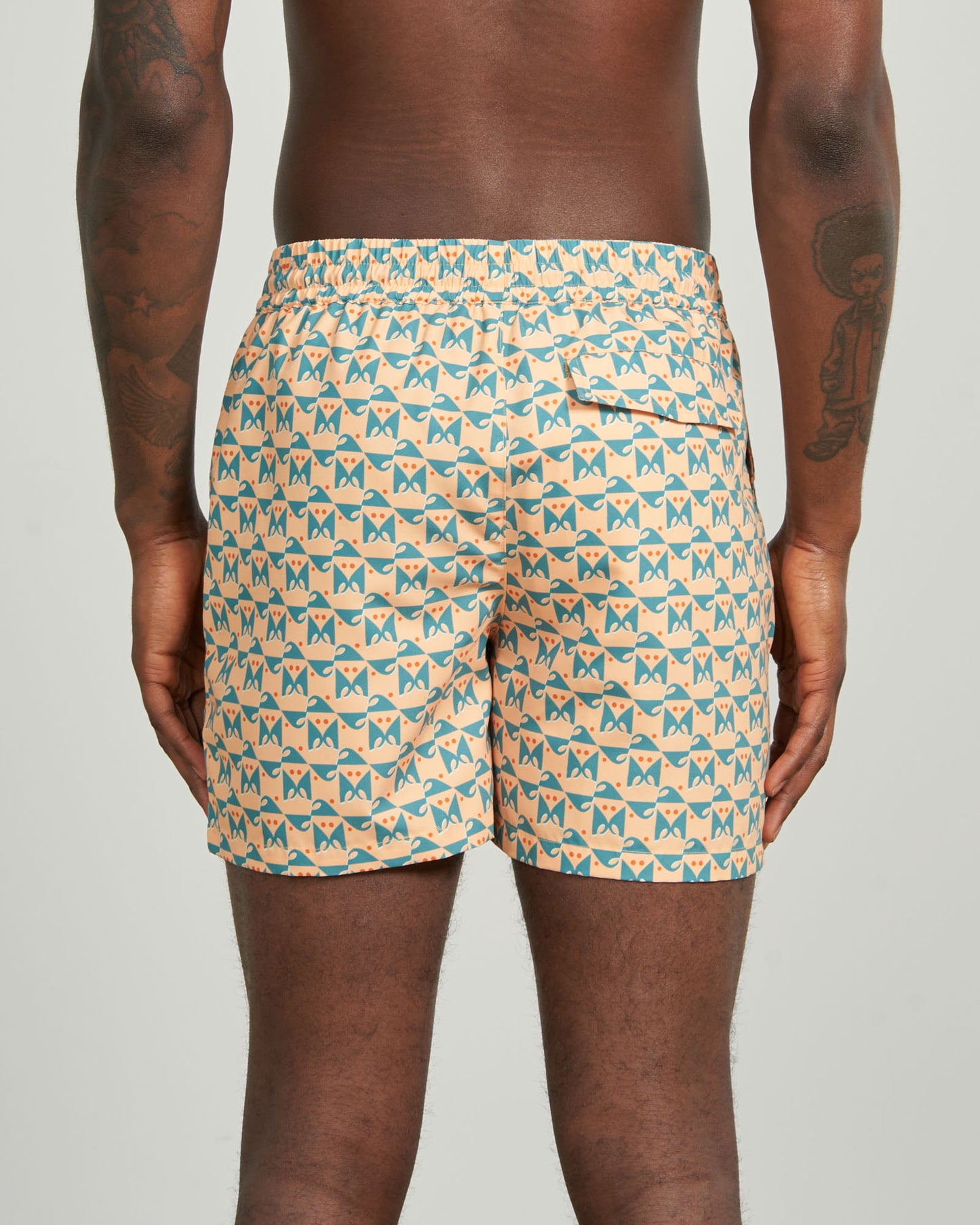 Buff Orange Recycled Swim Trunk - 5" (Back): Back view showing teal geometric butterfly print, elastic waistband, back pocket