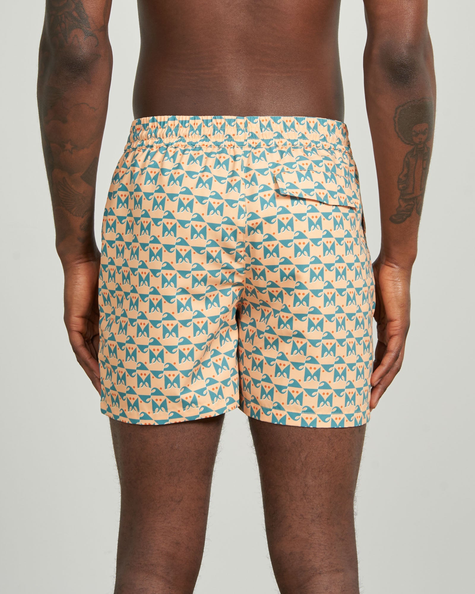 Buff Orange Recycled Swim Trunk - 5" (Back): Back view showing teal geometric butterfly print, elastic waistband, back pocket