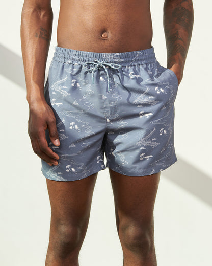 Stone Blue Recycled Swim Trunk - 5" (In-use): Steel blue swim trunks with white beach scene print and drawstring waist