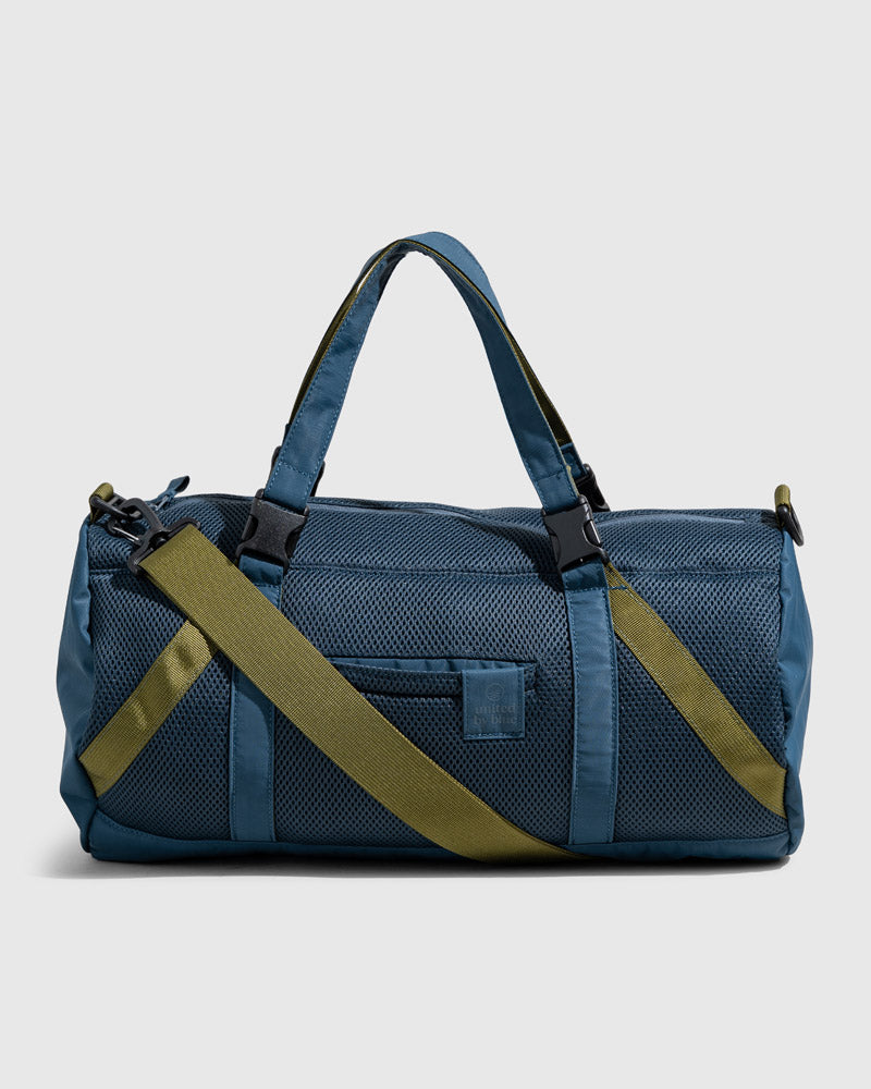 Blueberry (Re)active™ 16L Mini Duffle (Angle): Teal cylindrical bag with olive crossbody strap, mesh front pocket, top handles