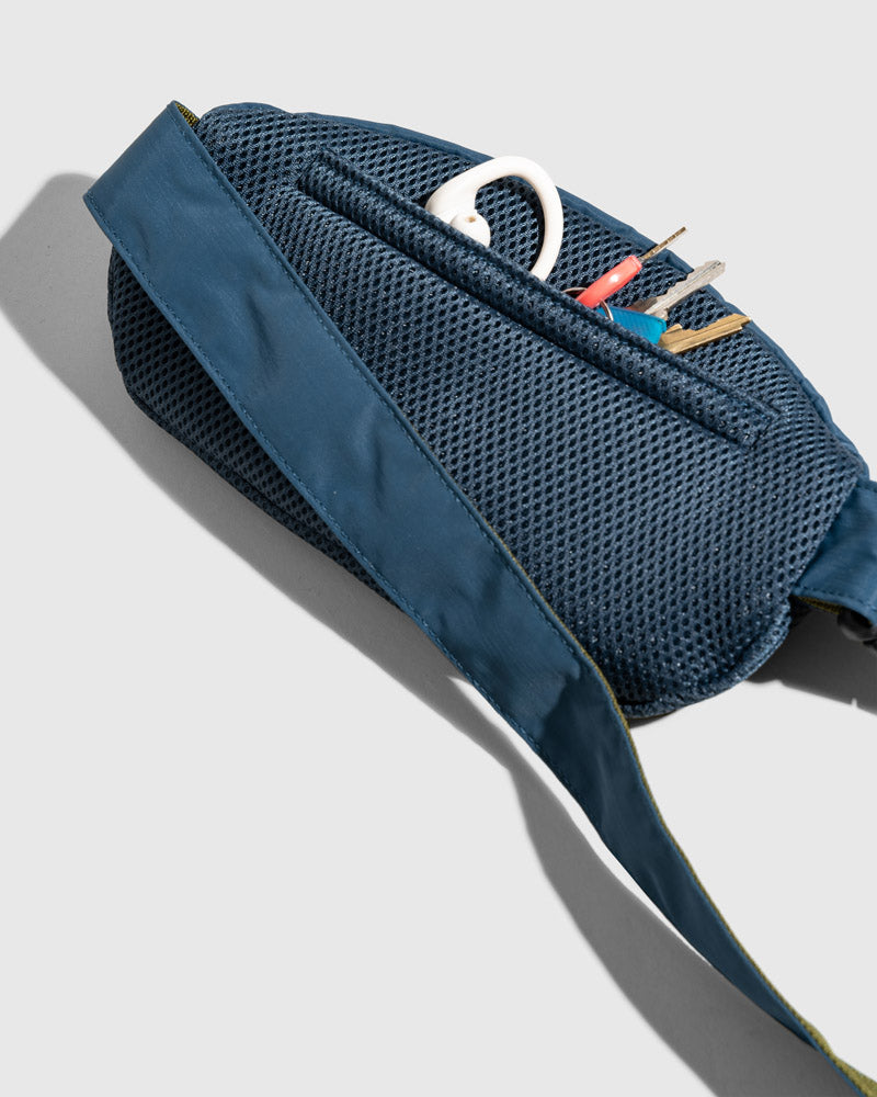 Deep Sea (Re)active™ 1L Fanny Pack (Detail): Navy mesh back panel open, revealing keys and a white carabiner clip