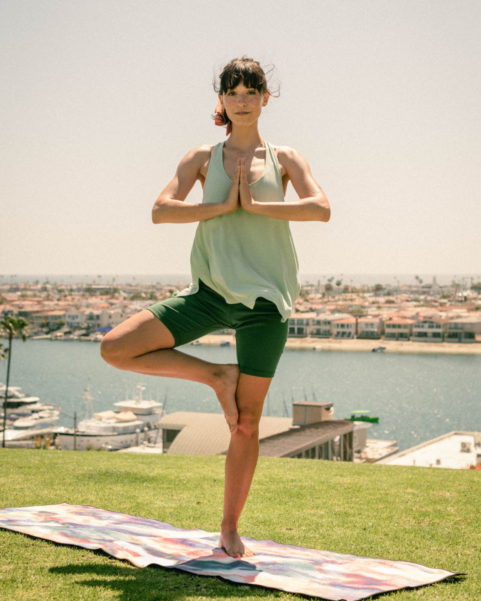 Jade EcoKnit™ Ribbed Bike Short (In-use): Woman in tree pose on colorful yoga mat, waterfront backdrop