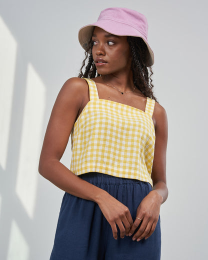 Cream Gold Linen Cropped Tank (In-use): Yellow and white gingham sleeveless cropped tank with square neckline, worn by woman