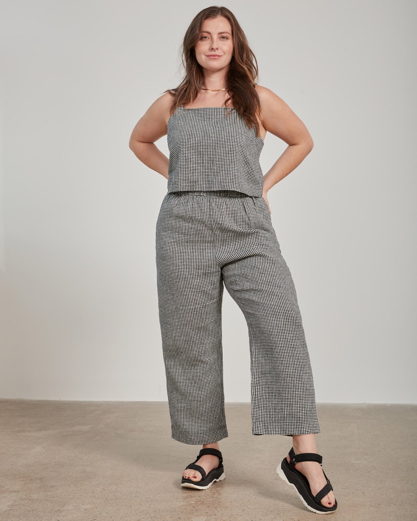 Black Linen Cropped Tank (In-use): Black and white gingham cropped tank with thin straps, worn by woman