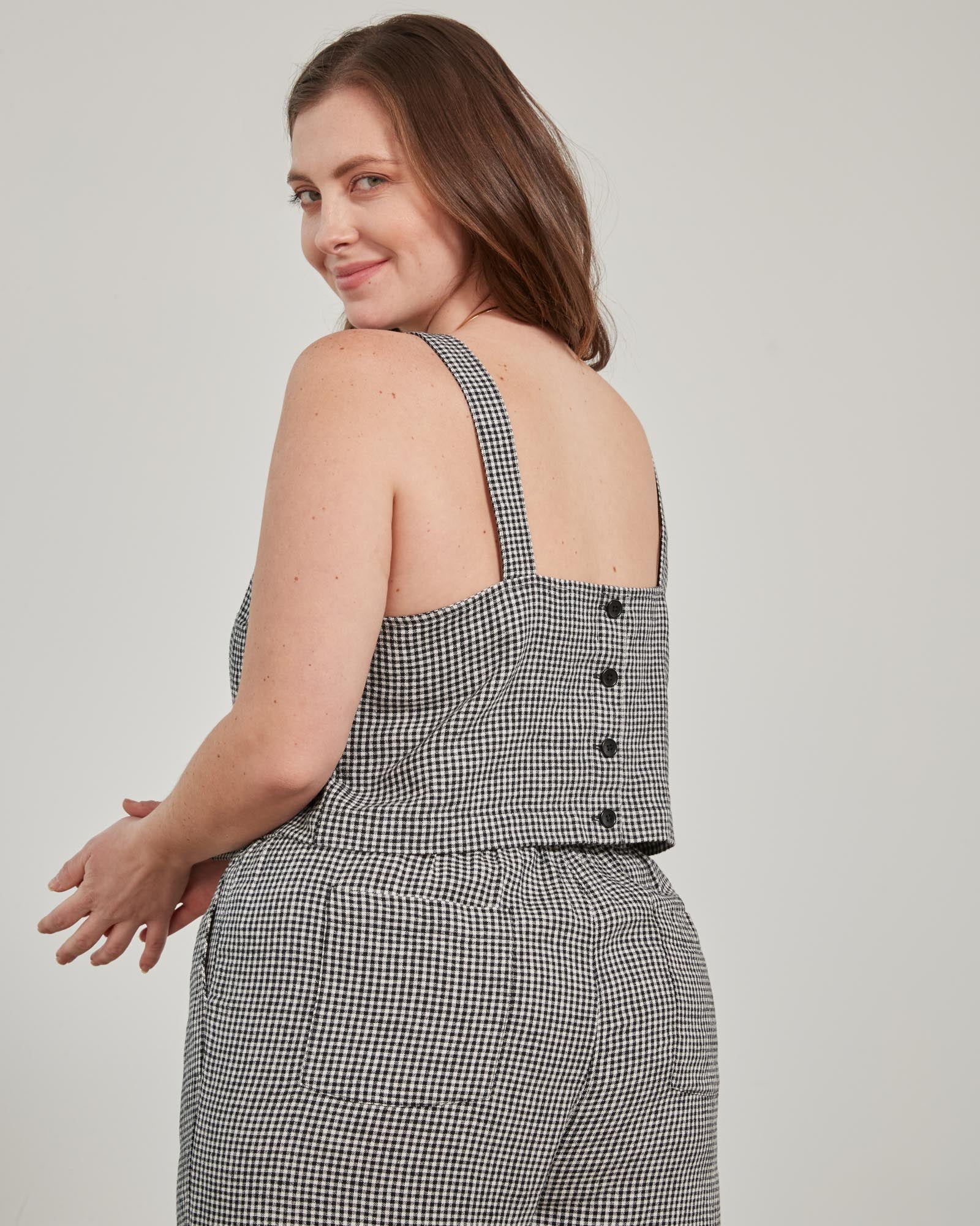 Black Linen Cropped Tank (Back): Back view of black gingham cropped tank with button closure, worn by model